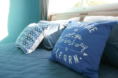 a bed with pillows on it with the words are best way to camp at Turtle Rooms in Bang Tao Beach