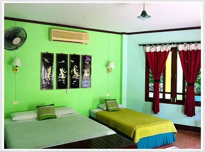 two beds in a room with green walls and windows at The Emerald Krabi Beach Resort in Klong Muang Beach