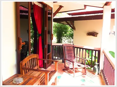 a porch with two rocking chairs on a house at The Emerald Krabi Beach Resort in Klong Muang Beach