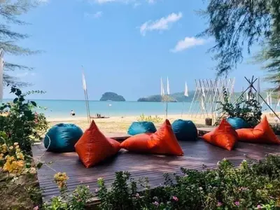 a group of red and blue pillows on a table near the beach at The Emerald Krabi Beach Resort in Klong Muang Beach