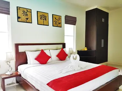 a bedroom with a large bed with red and white pillows at Prima Villas Karon Beach by PHR in Karon Beach