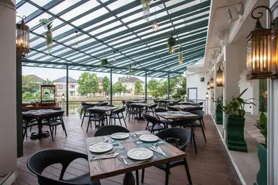 a restaurant with tables and chairs and a glass ceiling at Supicha Pool Access Hotel - SHA Plus in Phuket Town