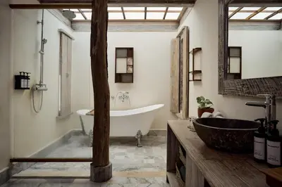 a bathroom with a tub and a large mirror at Dinso Resort & Villas Phuket, Vignette Collection by IHG in Patong Beach