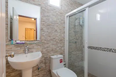 a bathroom with a toilet and a sink and a shower at Phant at Thalang Service Apartment in Thalang