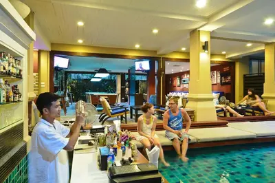 a group of people sitting around a pool in a hotel at Burasari Phuket Resort & Spa in Patong Beach