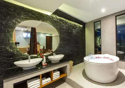a bathroom with two sinks and a large mirror at IndoChine Resort and Villas in Patong Beach