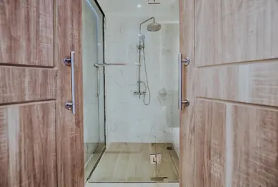 a bathroom with a shower and a wooden door at Days Inn by Wyndham Aonang Krabi in Ao Nang Beach