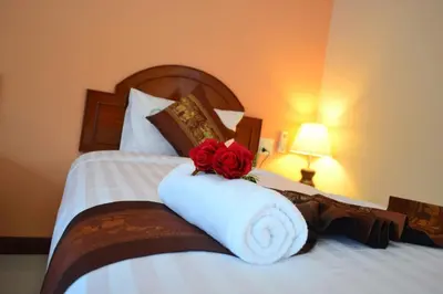 a bed with a white towel with a rose on it at Aonang Village Resort in Ao Nang Beach