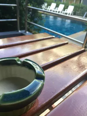 a toilet sitting on top of a wooden table next to a pool at Aonang Village Resort in Ao Nang Beach