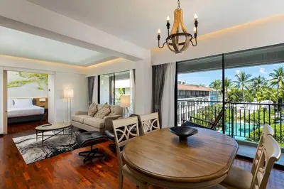 a living room with a dining table and a living room at DoubleTree by Hilton Phuket Banthai Resort in Patong Beach