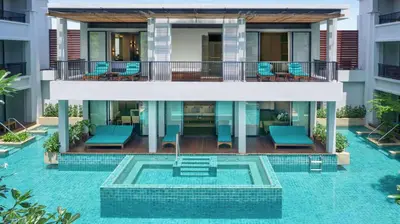 a villa with a pool in front of a building at DoubleTree by Hilton Phuket Banthai Resort in Patong Beach