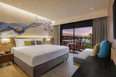 a hotel room with a bed and a balcony at DoubleTree by Hilton Phuket Banthai Resort in Patong Beach