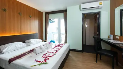a hotel room with a bed with flowers on it at Hotel Sole in Patong Beach