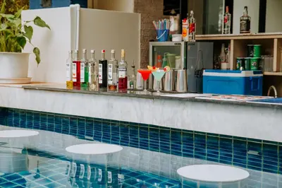 a swimming pool with a bar and some drinks at Blue Tara Hotel Krabi Ao Nang in Ao Nang Beach