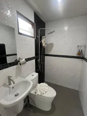 a white bathroom with a sink and a toilet at J2 Airport Mansion in Nai Yang Beach