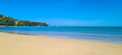 a beach with some boats in the water at Andaman Seaside Resort Bangtao Beach in Bang Tao Beach