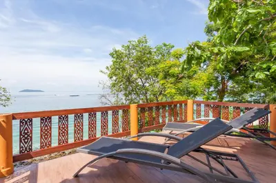 two chairs sitting on a deck overlooking the water at Phi Phi Natural Resort in Phi Phi Don
