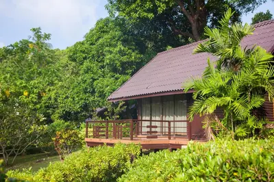 a small building with a brown roof and trees at Phi Phi Natural Resort in Phi Phi Don