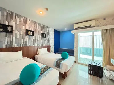 two beds in a room with blue walls at Benyada Lodge - Surin Beach in Surin Beach