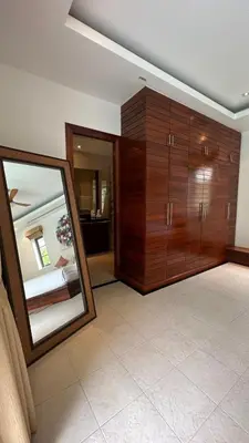 a living room with a mirror and wooden cabinets at The Residence Resort in Bang Tao Beach