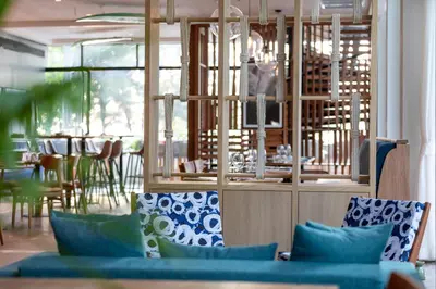 a dining room with blue chairs and a table at OUTRIGGER Surin Beach Resort in Surin Beach