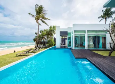 a house with a swimming pool next to the beach at Aleenta Phuket - Phang Nga - The Leading Hotels of the World in Natai Beach