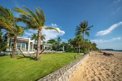 a house on the beach with palm trees at Aleenta Phuket - Phang Nga - The Leading Hotels of the World in Natai Beach