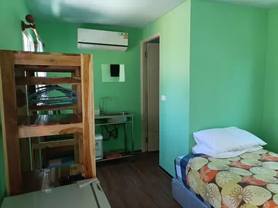 a bedroom with green walls and a bed and a sink at Chill land house in Bang Tao Beach