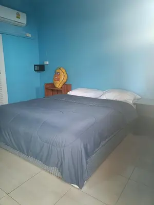 a bed in a room with a blue wall at Chill land house in Bang Tao Beach