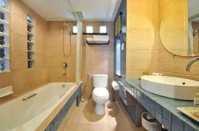 a bathroom with a tub and a toilet and a sink at Woraburi Phuket Resort & Spa - SHA Plus in Karon Beach