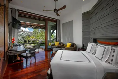 a bedroom with a bed and a living room at The Slate, Phuket in Nai Yang Beach