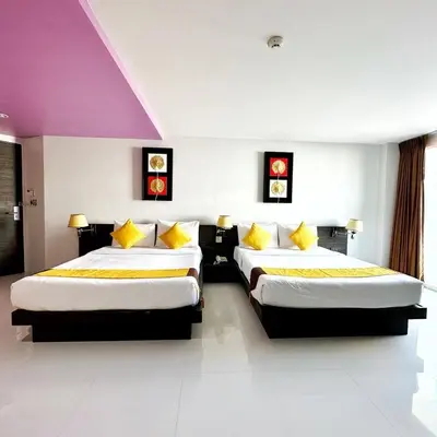 a hotel room with two beds with yellow pillows at Twin Hotel in Phuket Town