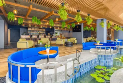 a restaurant with blue tables and chairs and a bar at Deevana Plaza Phuket - SHA Extra Plus in Patong Beach