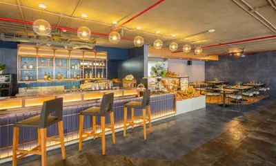 a restaurant with a bar with chairs and tables at Deevana Plaza Phuket - SHA Extra Plus in Patong Beach