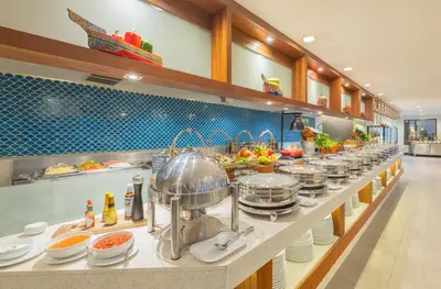a buffet line with many pots and pans of food at Deevana Plaza Phuket - SHA Extra Plus in Patong Beach