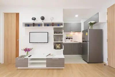 a kitchen with a white counter and a refrigerator at Ozone Condotel by RESAVA in Kata Beach
