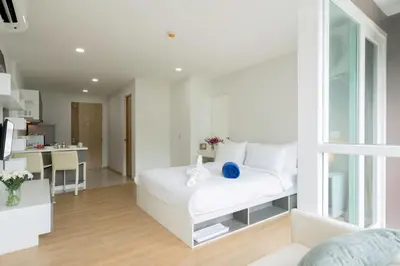 a white bedroom with a white bed in a room at Ozone Condotel by RESAVA in Kata Beach