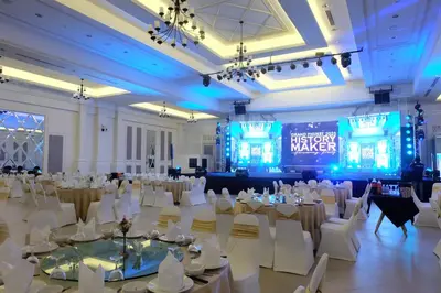 a banquet hall with white tables and chairs and a stage at Bhukitta Boutique Hotel Phuket Town in Phuket Town