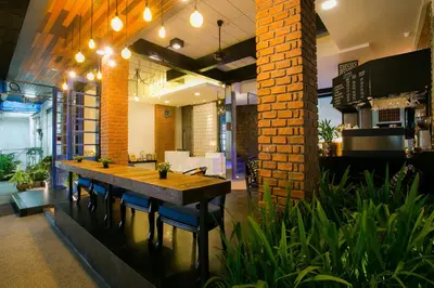 a dining room with a table and some plants at The House Patong in Patong Beach