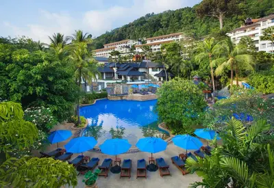 an aerial view of a resort pool with umbrellas at Diamond Cliff Resort & Spa, Patong Beach in Patong Beach