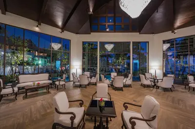 a waiting room with chairs and tables and windows at Diamond Cliff Resort & Spa, Patong Beach in Patong Beach