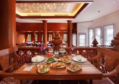 a dining room with a table with food on it at Diamond Cliff Resort & Spa, Patong Beach in Patong Beach