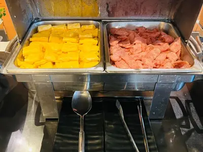 a tray of different types of food with a spoon at Baramee Resortel in Patong Beach
