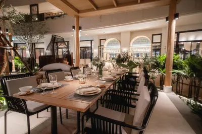 a long wooden table in a restaurant with chairs at M Social Hotel Phuket in Patong Beach
