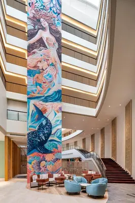 a lobby with a large painting on the wall at M Social Hotel Phuket in Patong Beach