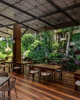 a restaurant with tables and chairs on a wooden floor at Pakasai Resort in Ao Nang Beach