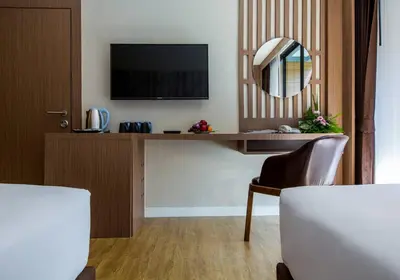 a room with a desk with a television and a mirror at GLOW Ao Nang Krabi in Ao Nang Beach