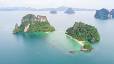 an island in a body of water with mountains at 9 Hornbills Tented Camp in Ko Yao Noi