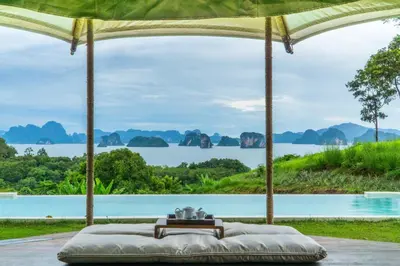 a bed with a view of a body of water at 9 Hornbills Tented Camp in Ko Yao Noi