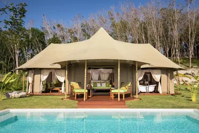 a gazebo with chairs and a pool at 9 Hornbills Tented Camp in Ko Yao Noi